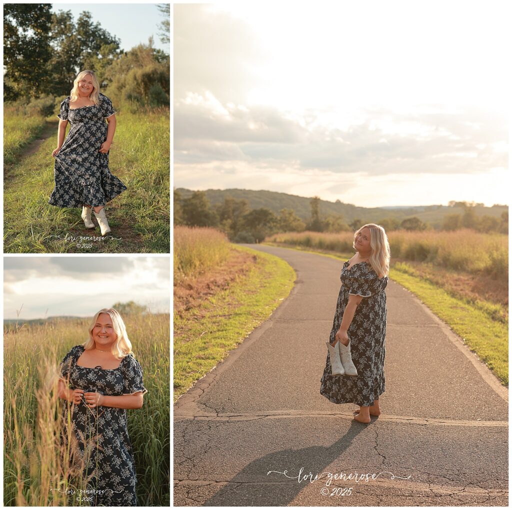 High school senior portrait session at Trexler Nature Preserve in Schnecksville PA by Lehigh Valley senior photographer Lori Generose of LG Photography featuring a blonde teen girl in a black floral dress and white cowboy boots posing in tall grass walking on a country road at sunset and holding her boots with mountain views in the background
