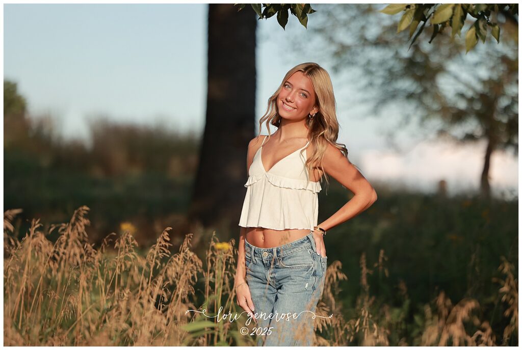 Northampton Area High School senior girl smiling in a field during golden hour at her senior photoshoot by Lori Generose of LG Photography, a Lehigh Valley photographer specializing in senior portraits in the Lehigh Valley and Trexler Nature Preserve.