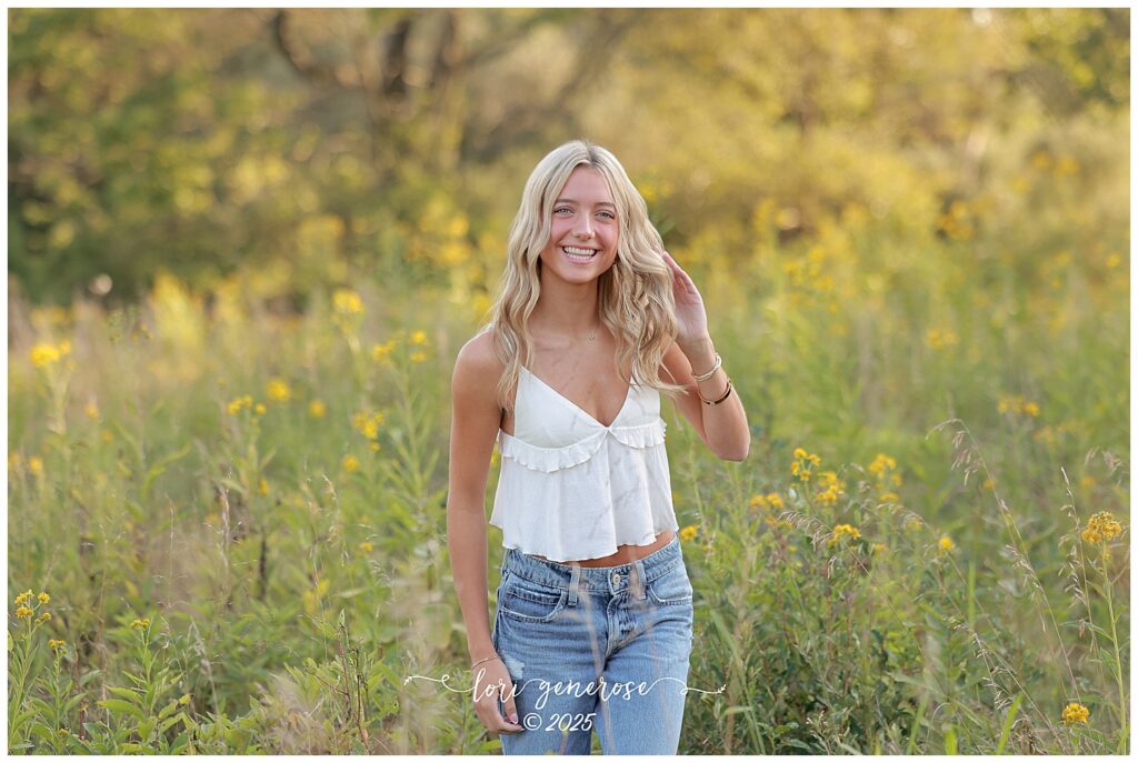 Northampton Area High School senior girl smiling in a field of yellow wildflowers during her senior photo session by Lori Generose of LG Photography, a Lehigh Valley photographer specializing in senior portraits in the Lehigh Valley and Trexler Nature Preserve in Schnecksville PA.