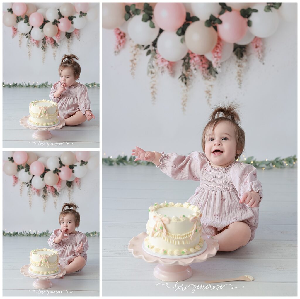 One year old girl cake smash portraits with pink and cream balloon garland with pink hanging wisteria flowers. Baby has a cream cake with vintage and pink bows from LG Photography, Lori Generose who is a Lehigh Valley cake smash photographer
