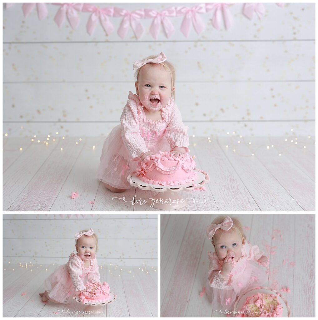 Three photo collage of one year old first birthday girl for her cake smash photoshoot on a white wood with gold flecks backdrop and a pink bow banner added. She is wearing a pink tulle onesie dress with one cursive written at the top and pink bows on her tulle skirt- she is looking right at the camera in one of the photos with both her hands in the cake pushing herself up, the next one she is also leaning into the cake with both hands and smiling and the last one she is putting cake in her mouth and the photo is looking down on her and the messy cake from above. Photos taken by Lehigh Valley Cake Smash Photographer Lori Generose of LG Photography