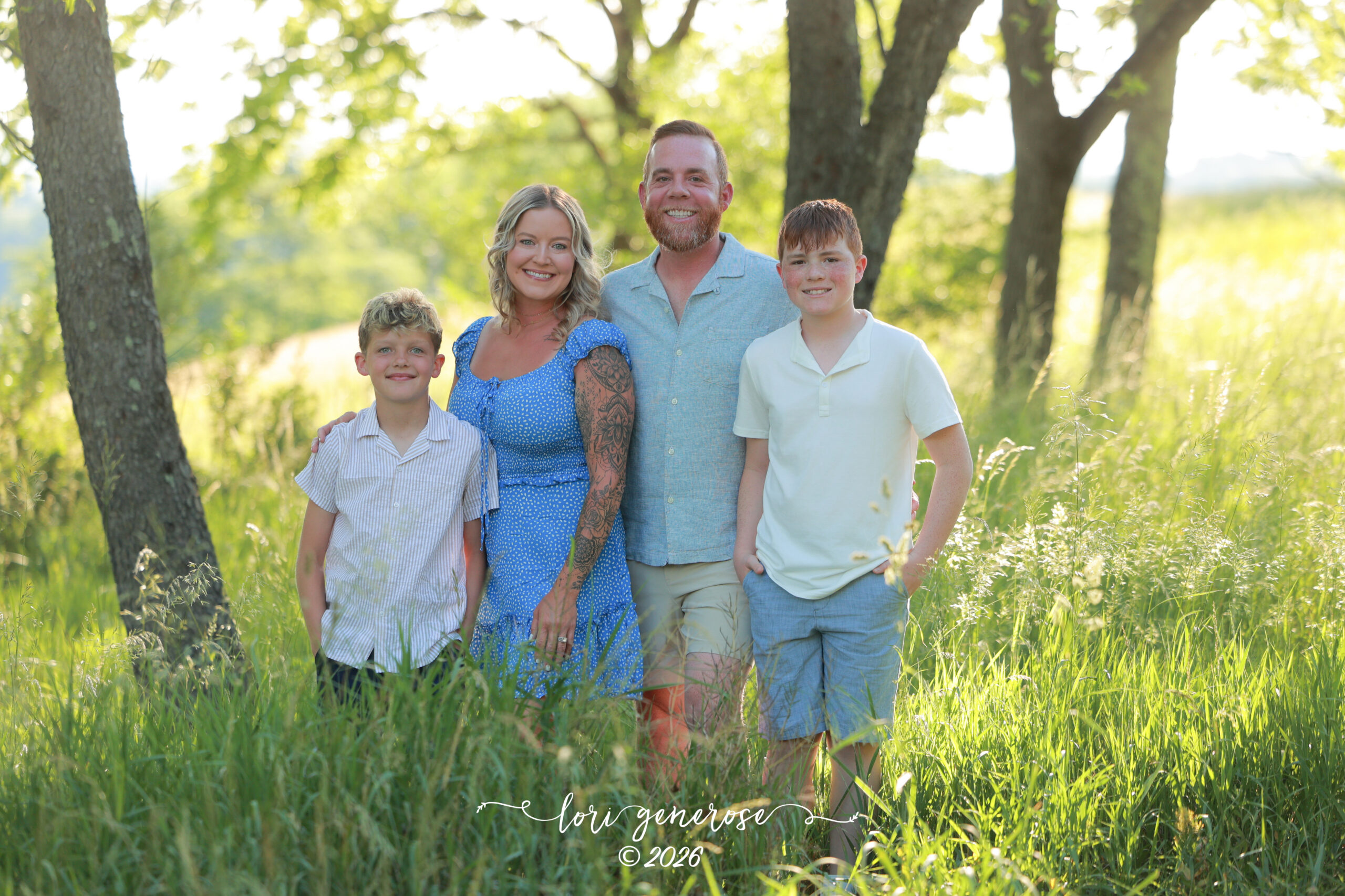 Family photoshoot of mom, dad and their two boys ages 11 and 13 posing in tall grasses in gorgeous light at Trexler Nature Preserve in Schnecksville, PA by Lehigh Valley Photographer, Lori Generose of LG Photography