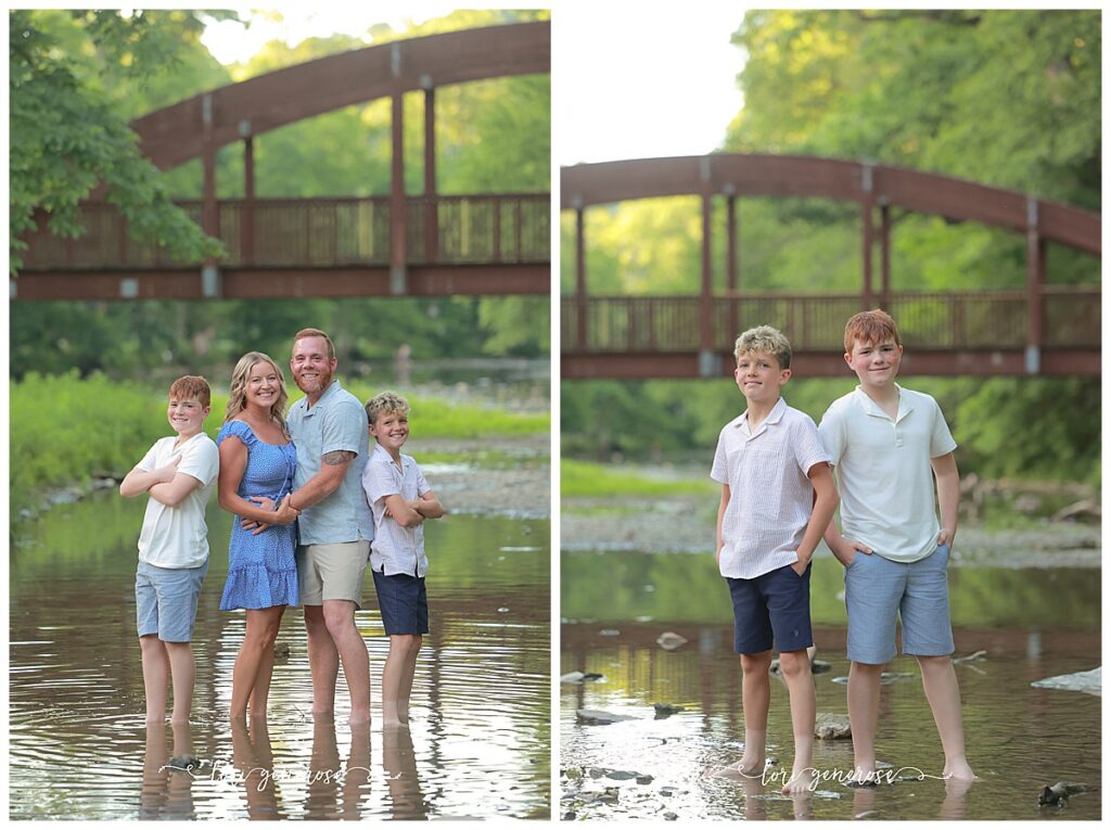 Family photoshoot of mom, dad and their two boys ages 11 and 13 in the water posing on a rock with a brown iron bridge behind them at Trexler Nature Preserve in Schnecksville, PA by Lehigh Valley Photographer, Lori Generose of LG Photography
